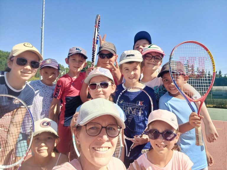Jeunes joueurs de tennis et leur encadrement réunis avec leurs raquettes sur un court extérieur à Lèves.